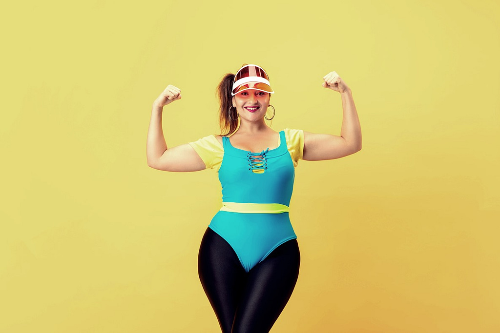 Young caucasian plus size female model's training on yellow background.