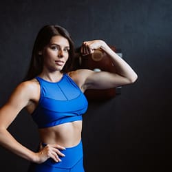 Fit woman posing on the camera. Personal trainer showing her form.