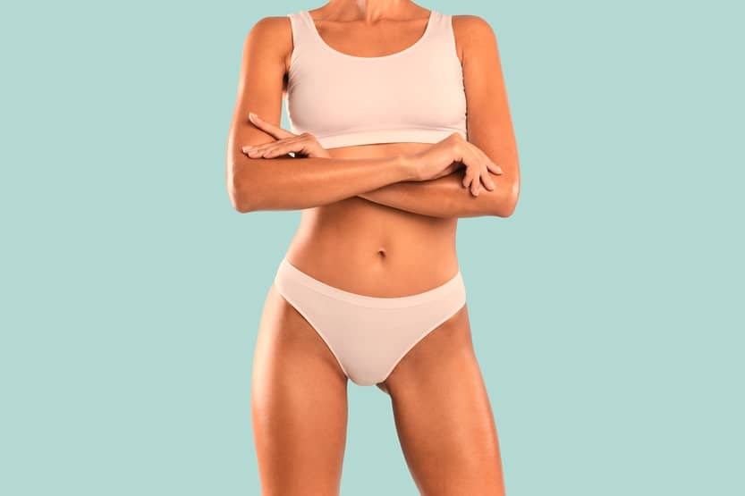 Closeup Cropped Frontal View Of Slim Lady With Perfect Body Shape And Flat Tummy Posing With Folded Arms